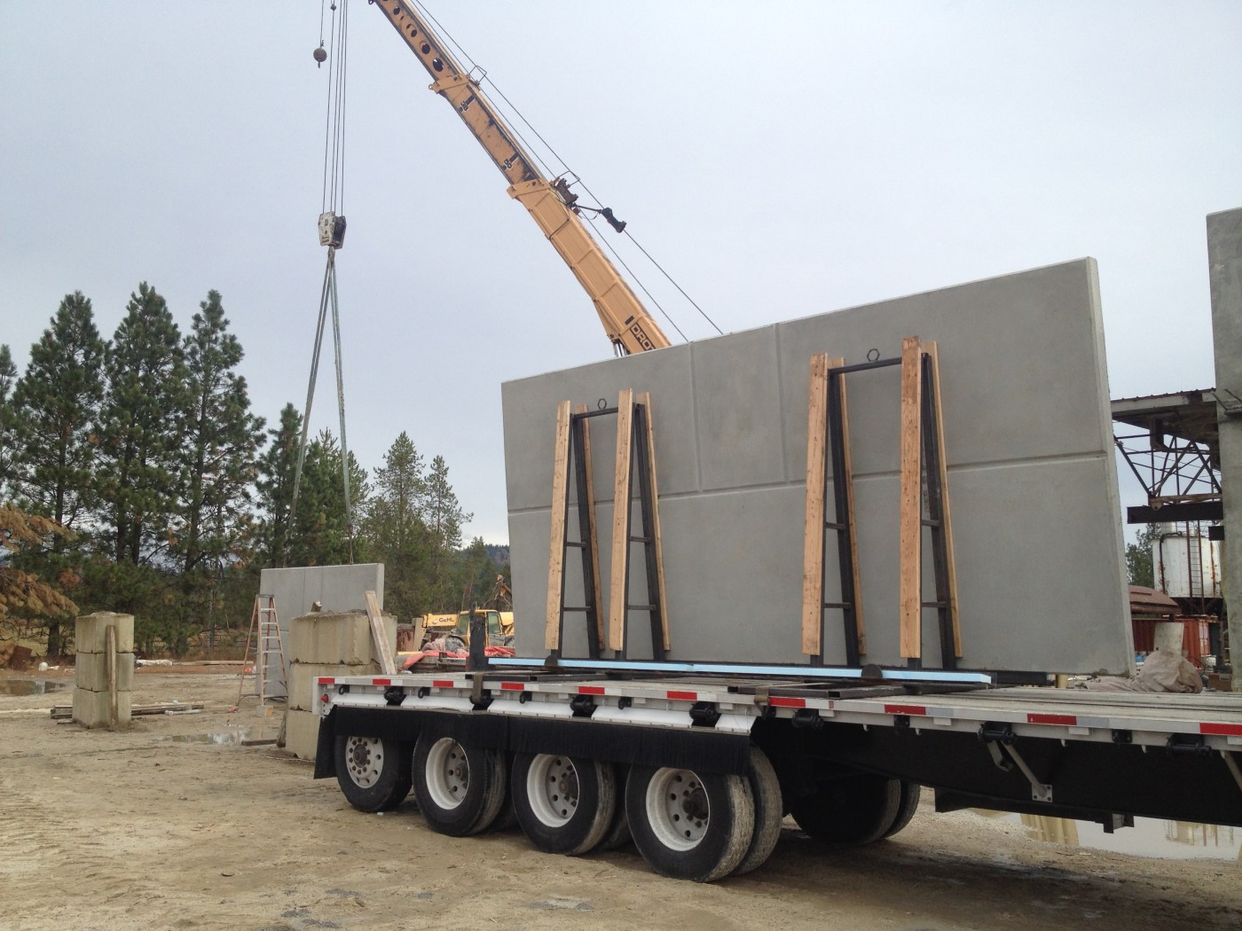 Crane setting a precast wall panel on a truck
